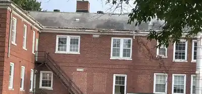 Brick corner of the former children's center, white windows and a metal fire escape